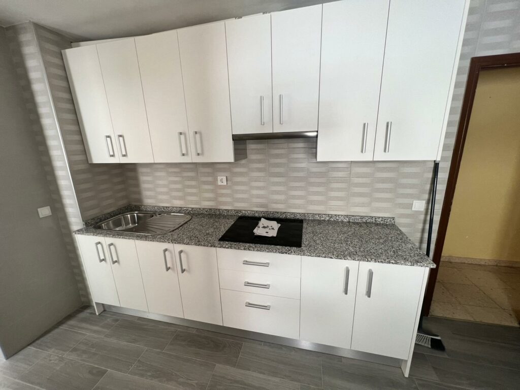 Encimera de granito gris en cocina blanca