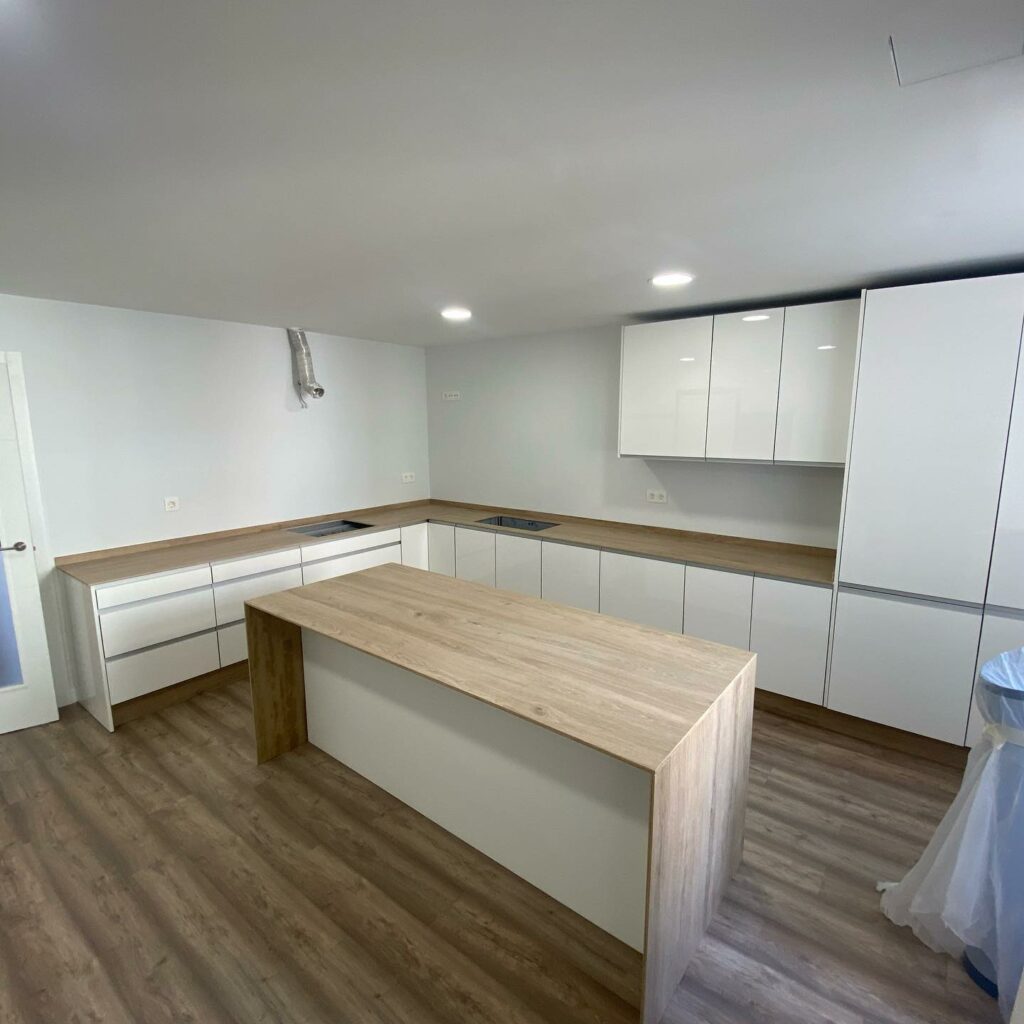 Cocina blanca con isla y encimera en tono madera